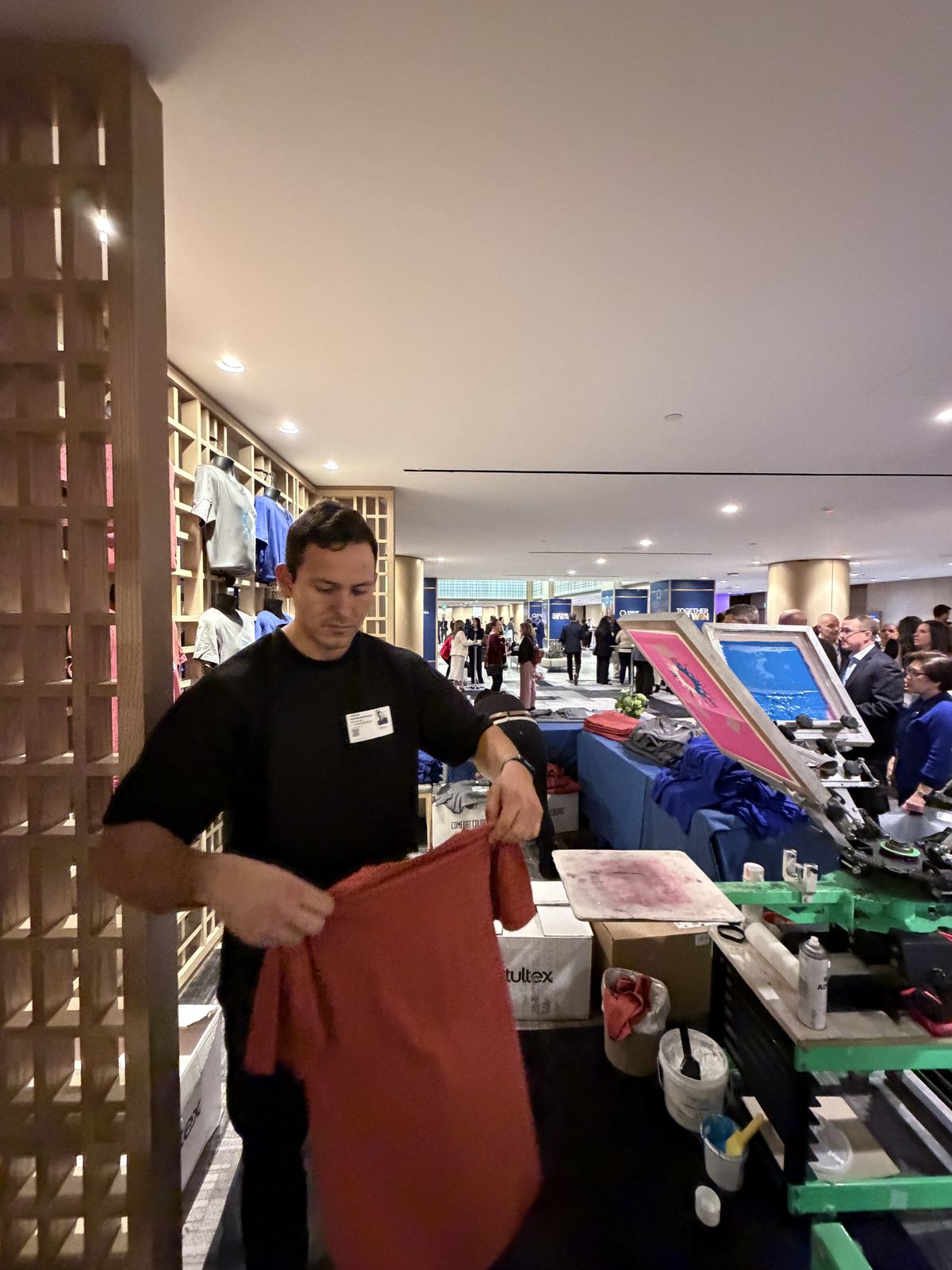 Event guests gathered around a live screen-printing press